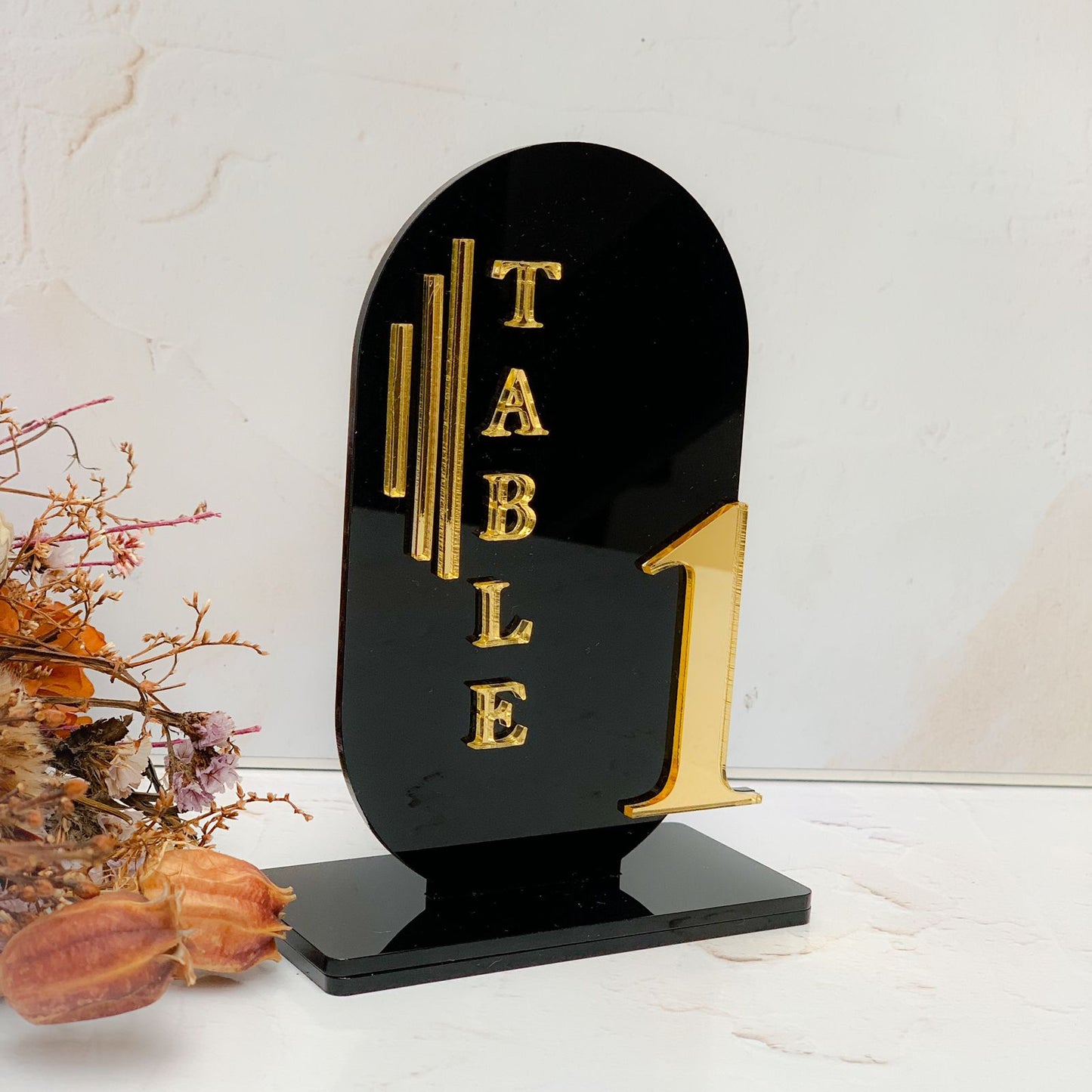 Black laser cut acrylic curved table number layered with gold mirror lettering and numbers