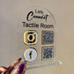 Clear acrylic sign with social media icons and QR codes held by a hand against a neutral background